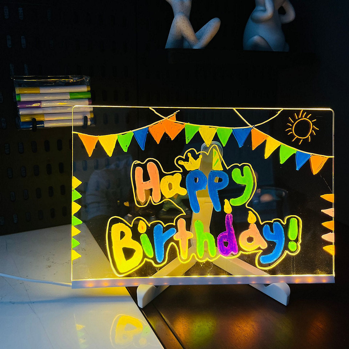 Glowing 'Happy Birthday!' sign with colorful letters on a stand.