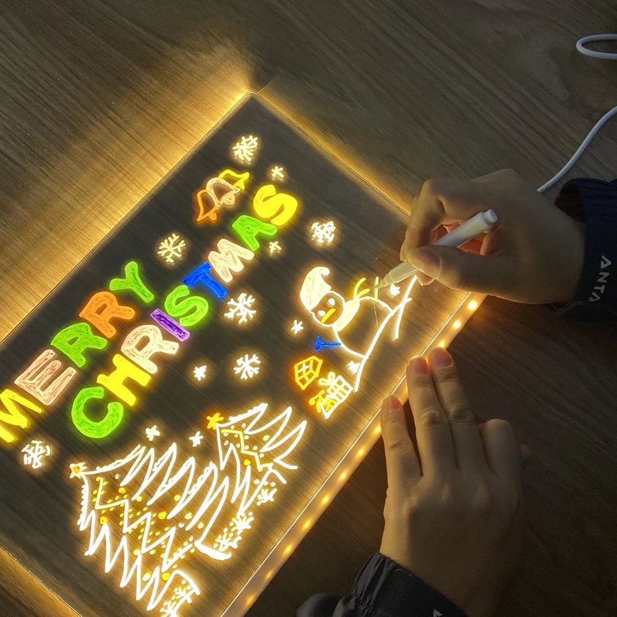 Person writing on a light-up Christmas-themed board with colorful letters.